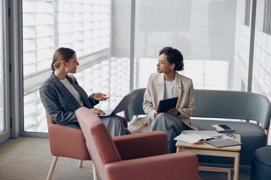 How to Give Feedback to Manager: 10 Scripts & Proven Tips 2 Two professionals engaged in business consulting services in a modern office setting in New York City, USA.