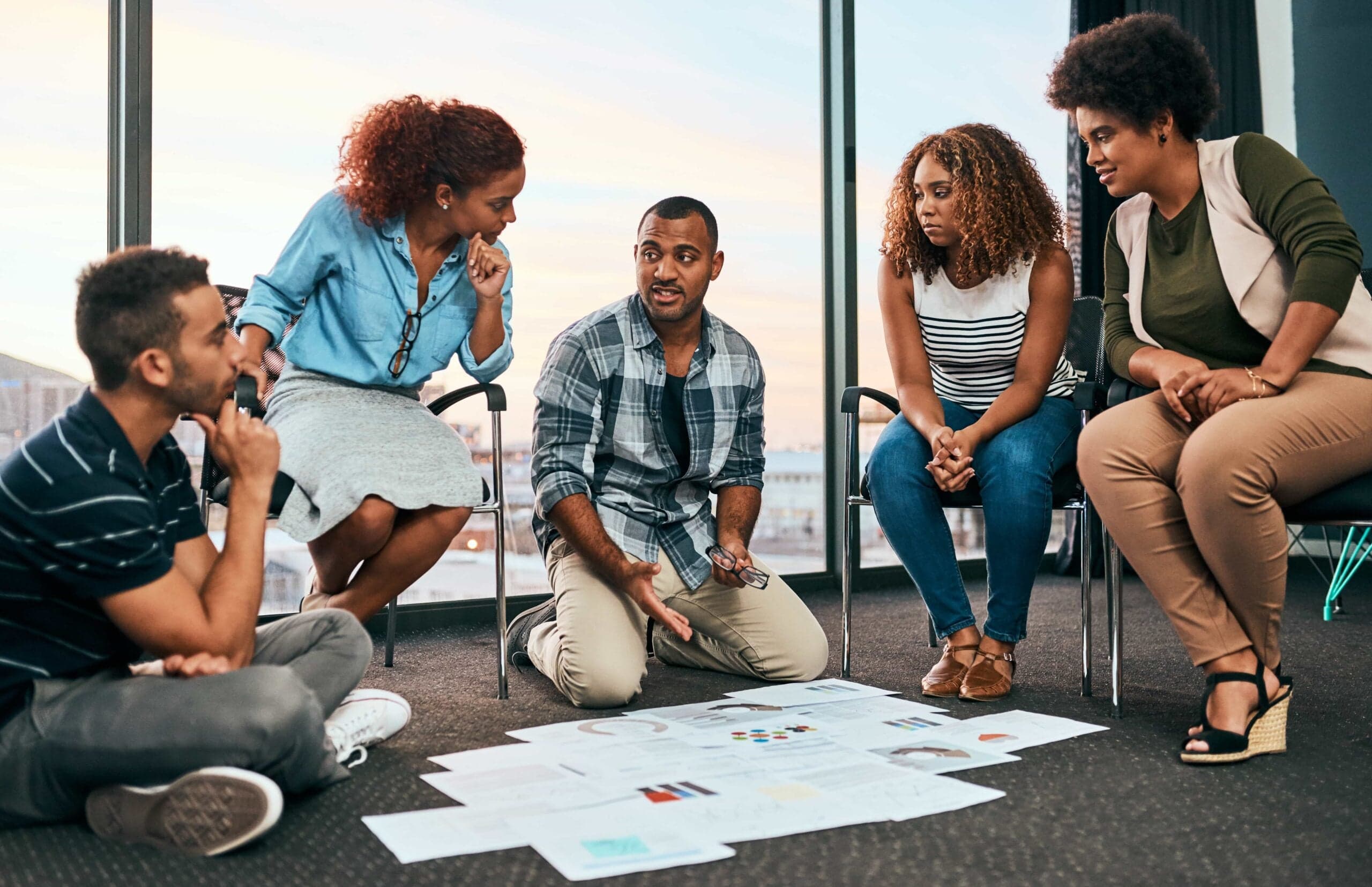 15+ Survey Questions About Employee Engagement (2026 Guide) 1 A diverse professional team brainstorming and reviewing strategy documents during a collaborative meeting in a bright office then Survey Questions About Employee Engagement in Charlotte, NC.