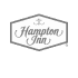 Hampton Inn logo featuring the brand name in script typography within a hexagonal border.
